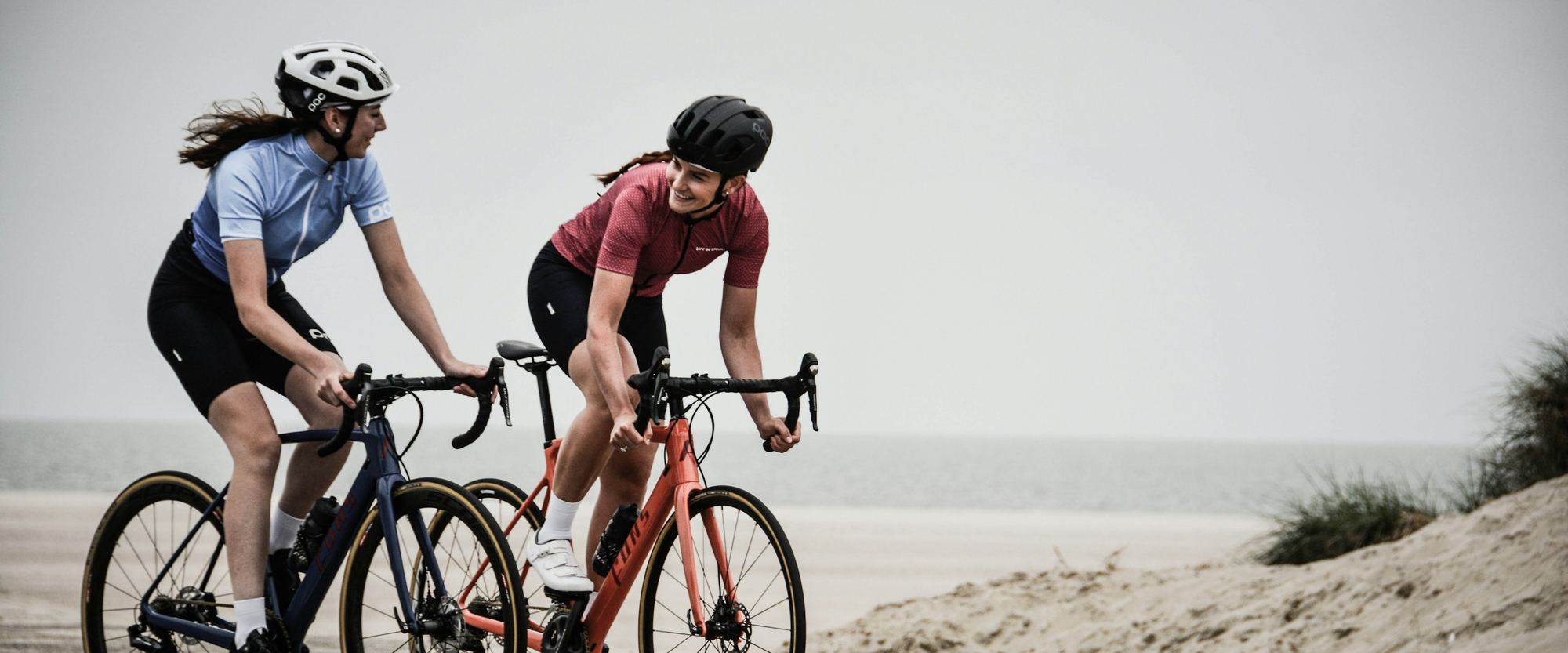 Two road cyclists riding a coastal road